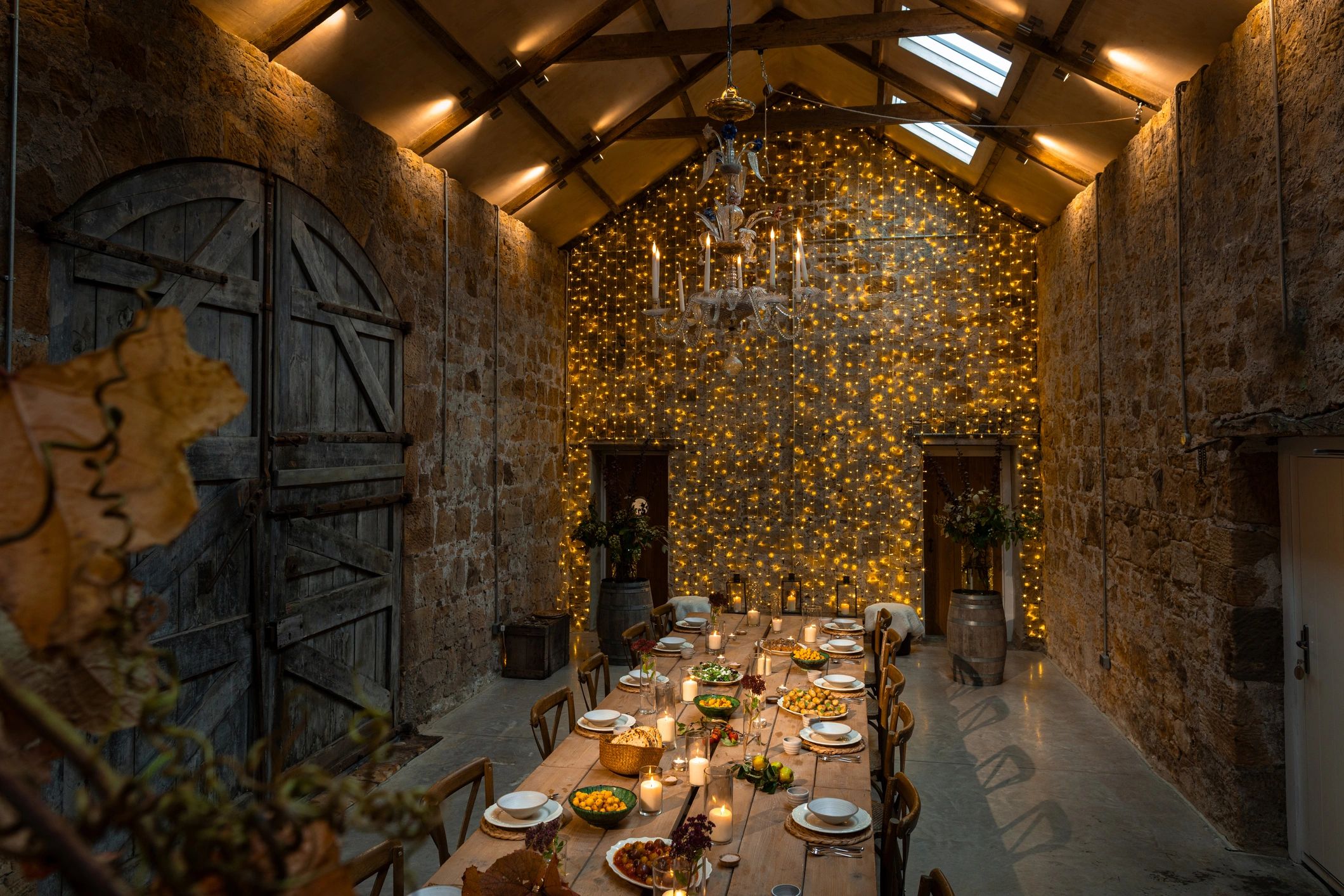 Celebration table styled with candles, food, and twinkle lights