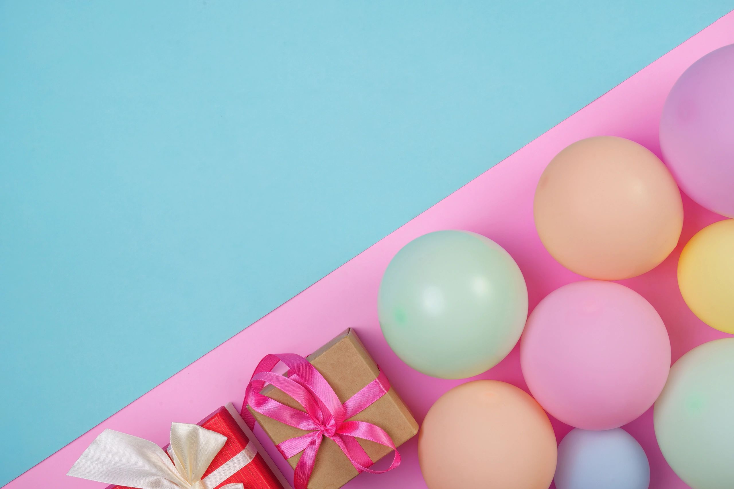 Pastel balloons and gift boxes arranged for a celebration-themed call to action